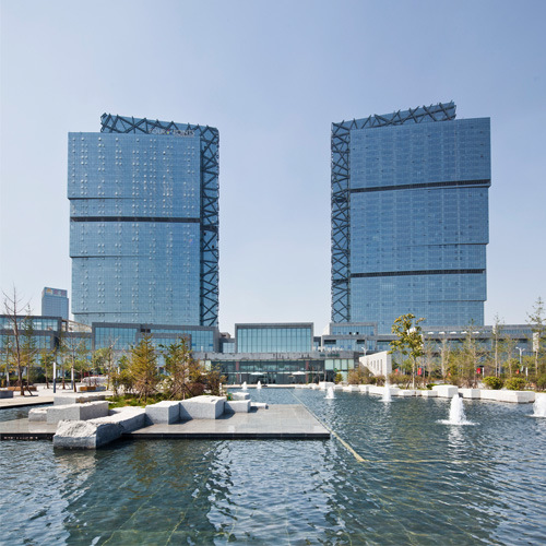 reflective bronze glass and mud brick walls as the best choice for reducing the air conditioning load on glass curtain walls outside the modern building.